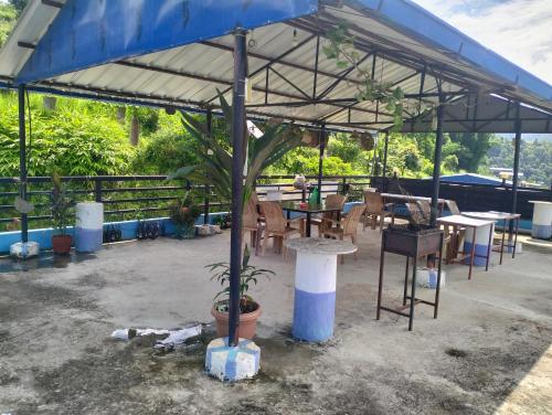 a pavilion with tables and chairs and a tree at Hotel bright moon lake in Deorāli