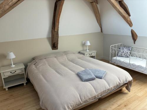a bedroom with a large bed and two night stands at La Maison du Clocher in Jupilles