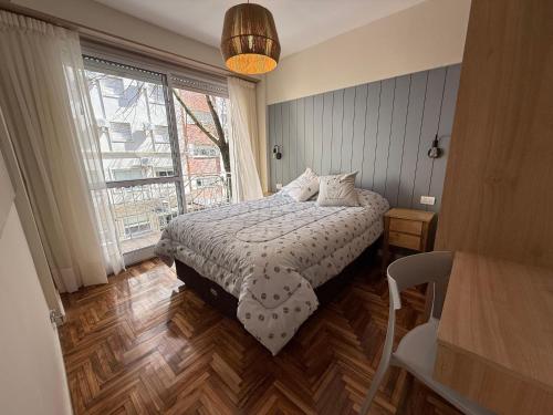 Un dormitorio con una cama y una ventana grande. en Departamento reciclado, en Mar del Plata