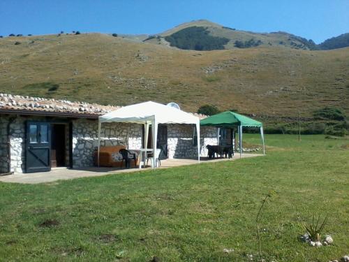 a stone house with a table and a tent at Chalet Vista Lago in San Gregorio