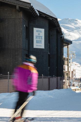 a person on skis in the snow in front of a building at Le Fitz Roy, a Beaumier hotel in Val Thorens