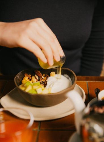a person is stirring a bowl of food with a spoon at Le Moulin, Lourmarin, a Beaumier Hotel in Lourmarin