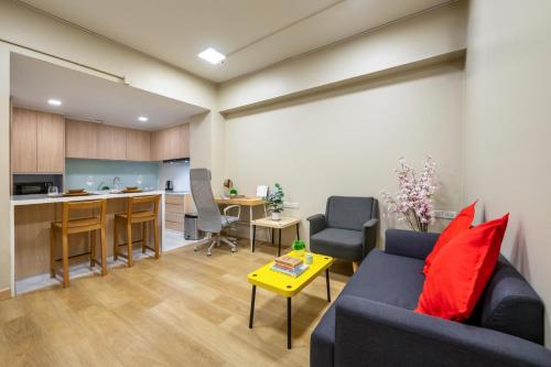 a living room with a couch and a kitchen at C2 stay Phayathai in Pom Prap