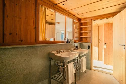ヴェンゲンにあるGrand Hotel Belvedere, a Beaumier Hotelの洗面台が2つと鏡があるバスルーム