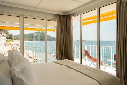 a bedroom with a bed and a view of the ocean at Les Roches Rouges, a Beaumier hotel in Saint-Raphaël
