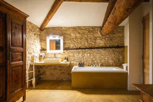Un baño con una bañera grande y un lavabo. en Le Galinier Lourmarin, a Beaumier Guesthouse, en Lourmarin