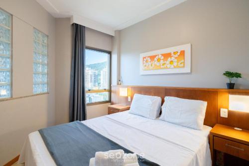 a hotel room with a bed and a window at Apto em Cond. c/ Piscina aquecida CUR0905 in Florianópolis