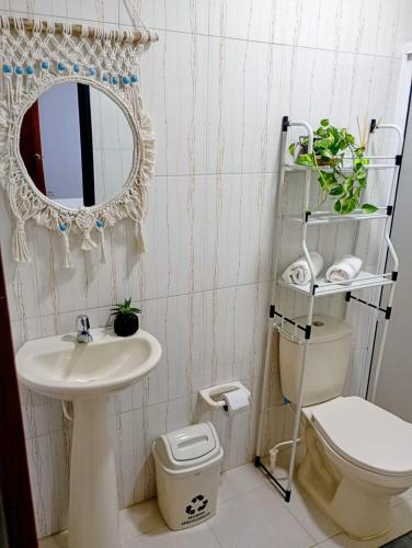 a bathroom with a sink and a toilet and a mirror at Sweet Home in Curití