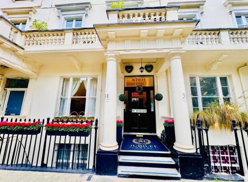 a white house with a front door with flowers at Jubilee Hotel Victoria in London