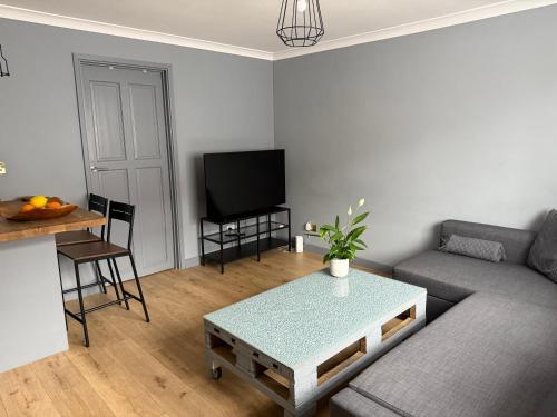 a living room with a couch and a table at Modern 1 bedroom flat in Morden in Morden