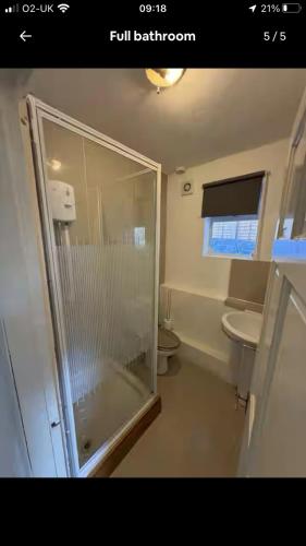 a bathroom with a glass shower and two toilets at Good Heart in Birmingham