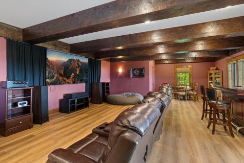 a living room with a leather couch and a table at Cardinal Perch in Beech Mountain