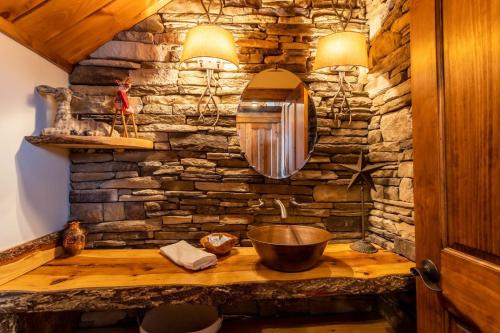Baño de piedra con lavabo y espejo en Cardinal Perch, en Beech Mountain