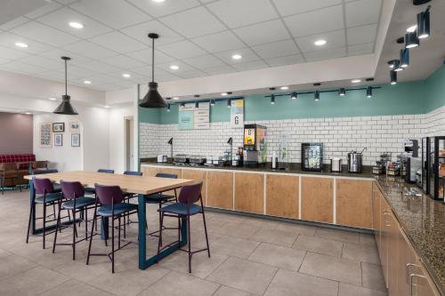 a restaurant with a table and chairs and a counter at Garner Hotel Paducah West in Paducah