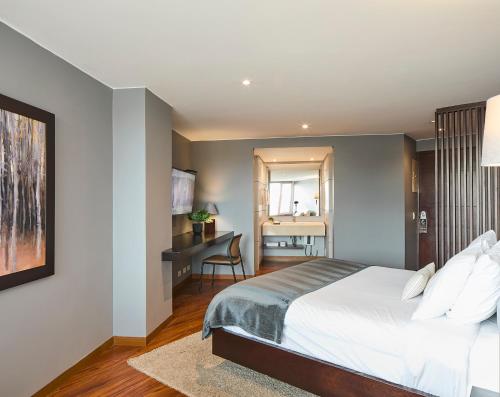a bedroom with a bed and a desk in it at Nico Apartasuites in Bogotá