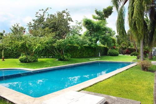 a swimming pool in the yard of a house at Casa Chinelo Alberca Wifi cerca hospital ISSSTE UTEZ DIEZ in Temixco