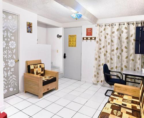 a waiting room with a table and a chair at Casa Chinelo Alberca Wifi cerca hospital ISSSTE UTEZ DIEZ in Temixco