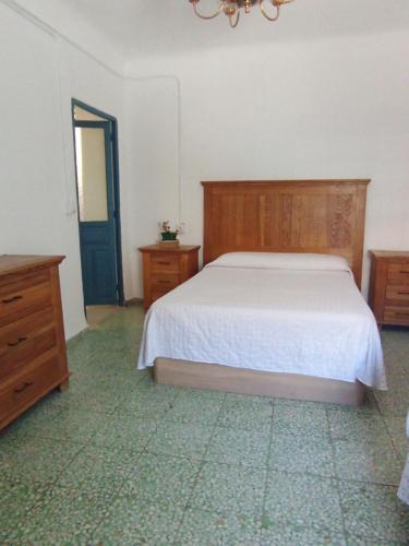 a bedroom with a bed and a blue door at Casa rural Ismael in El Acebrón