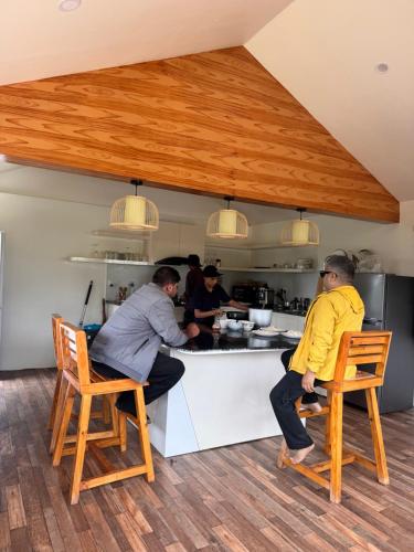 un gruppo di persone sedute al bancone di una cucina di Hideaway Glamping a Panaoti