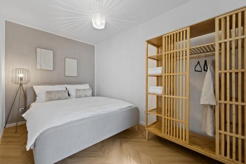 a bedroom with a large white bed and wooden shelves at Cozy living in Gießen - free parking - balcony in Gießen