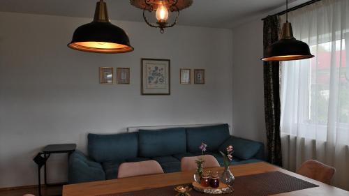 a living room with a blue couch and a table at Mystic Twistic in Vîrfurile
