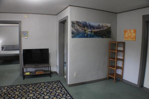 a room with a flat screen tv and a bedroom at WP2 Pet Friendly Keweenaw Apt w EV Charger Onsite in Calumet