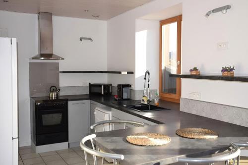 a kitchen with a table and some chairs in it at Gîte La Bandsäge rando,rivière,quietude 