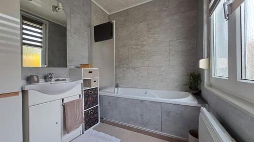 un baño con lavabo y bañera en La P'tite Maison..., en Sickert