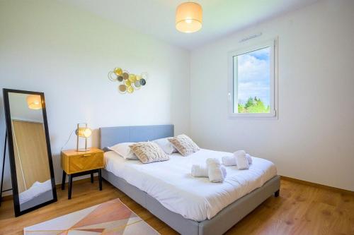 Un dormitorio con una cama con sábanas blancas y una ventana. en Ma bonne étoile, en Anould