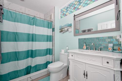 a bathroom with a toilet and a sink and a mirror at Cedar Key Florida Condo at Park Place in Cedar Key