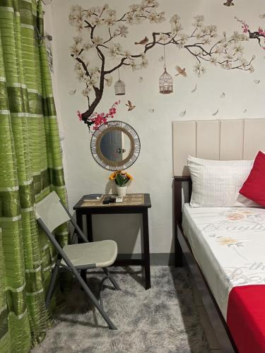 a bedroom with a bed and a table with a chair at YOO Darius' Residences in Moalboal