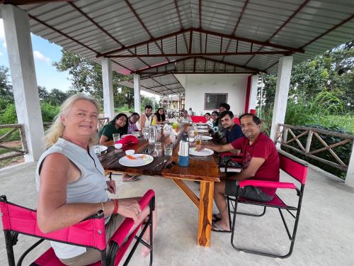 a group of people sitting around a wooden table at HOME in the JUNGLE in Seonī