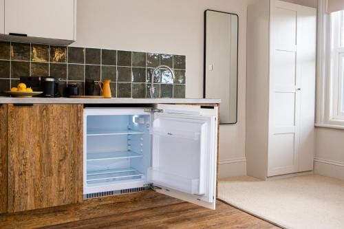 a kitchen with an open refrigerator with its door open at Settle Southampton - Stylish Self Check-In Rooms & Self Catering Suites in Southampton