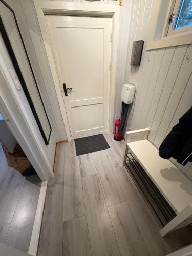 a hallway with a white door and a wooden floor at Beautiful panorama fjord wiew 40 min from Bergen in Hamre