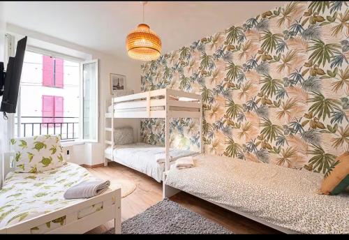 a bedroom with two bunk beds and a wall with palm trees wallpaper at Logement pour 8 personnes près de Disney & Paris in Chanteloup-en-Brie