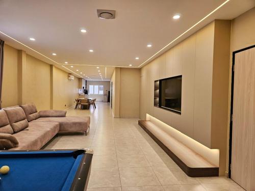 a living room with a couch and a pool table at Shmawai Homestay Tepi Sungai in Kota Tinggi
