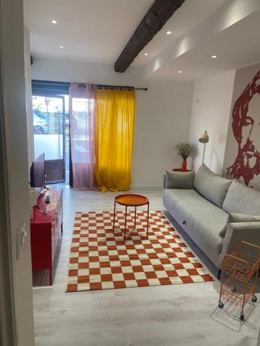 a living room with a couch and a table at Le pop Daudet in Fontvieille