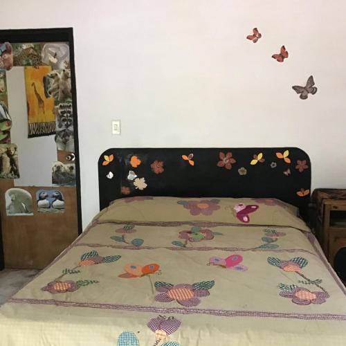 a bedroom with a bed with butterflies on the wall at Casa Bella in Taganga