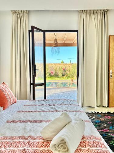 a bedroom with a bed and a sliding glass door at Chambre Agadir in Essaouira