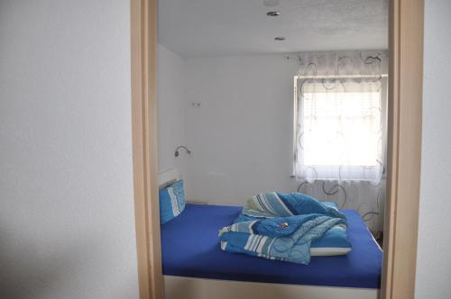 a small bedroom with a blue bed with a window at Kiefer-Apartments in Rust