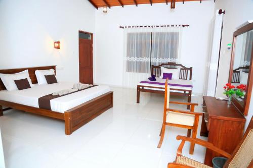 ein Schlafzimmer mit einem Bett, einem Schreibtisch und einem Stuhl in der Unterkunft Yathramulla Harbour Bentota in Bentota
