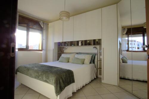 a bedroom with a large white bed and a window at Casa di Stefy in Quartu SantʼElena