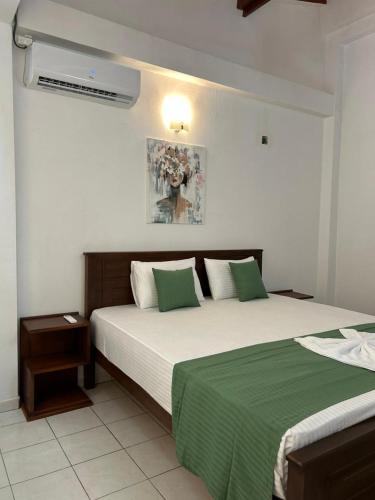 a bedroom with two beds with green and white sheets at Villa Petria in Galle
