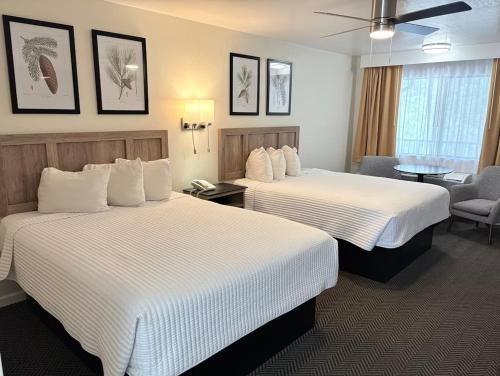 a hotel room with two beds and a chair at Cedar Lodge in El Portal