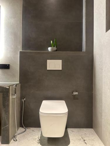 a bathroom with a white toilet and a plant at Secret House in Dickwella