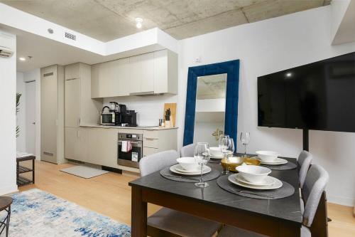 a dining room with a table with chairs and a television at Chic Hideaway - Downtown Hotspot in Montréal