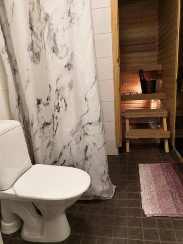 a bathroom with a toilet and a shower curtain at Convenient Studio for 1 with Sauna in Kemi