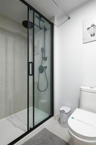 a bathroom with a glass shower with a toilet at Chic Hideaway - Downtown Hotspot in Montreal