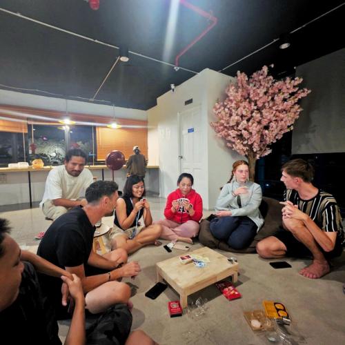 a group of people sitting on the floor in a room at Kinboshi Hostel Silom in Bangkok