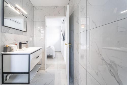 a white bathroom with a sink and a shower at Villa Rose Du Désert in Sainte-Anne